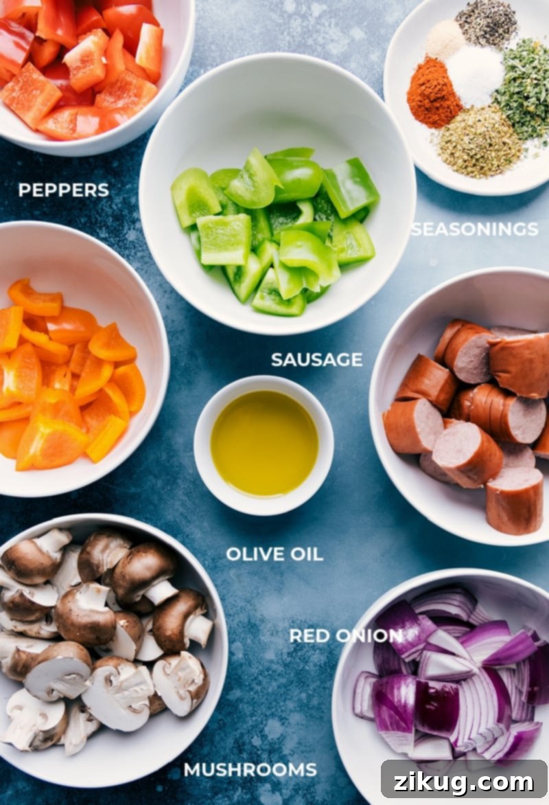 Sausage Kabobs! Recipe via ChelseasMessyApron #dinner #quick #easy #healthy #whole #whole30 #keto #veggies #grilled #summer #sausage #kabobs A vibrant flat lay image showcasing all the fresh ingredients for sausage kabobs: smoked sausage, various bell peppers, red onion, baby bella mushrooms, olive oil, and a selection of dried herbs and spices.