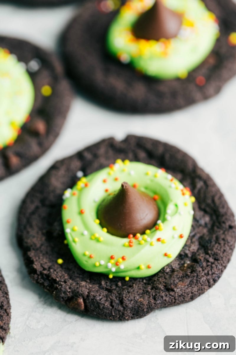 Only 4 ingredients to make these festive, fun, and most importantly DELICIOUS Halloween cookies! Halloween cookies decorated to look like a witch's hat with green frosting and a chocolate kiss.