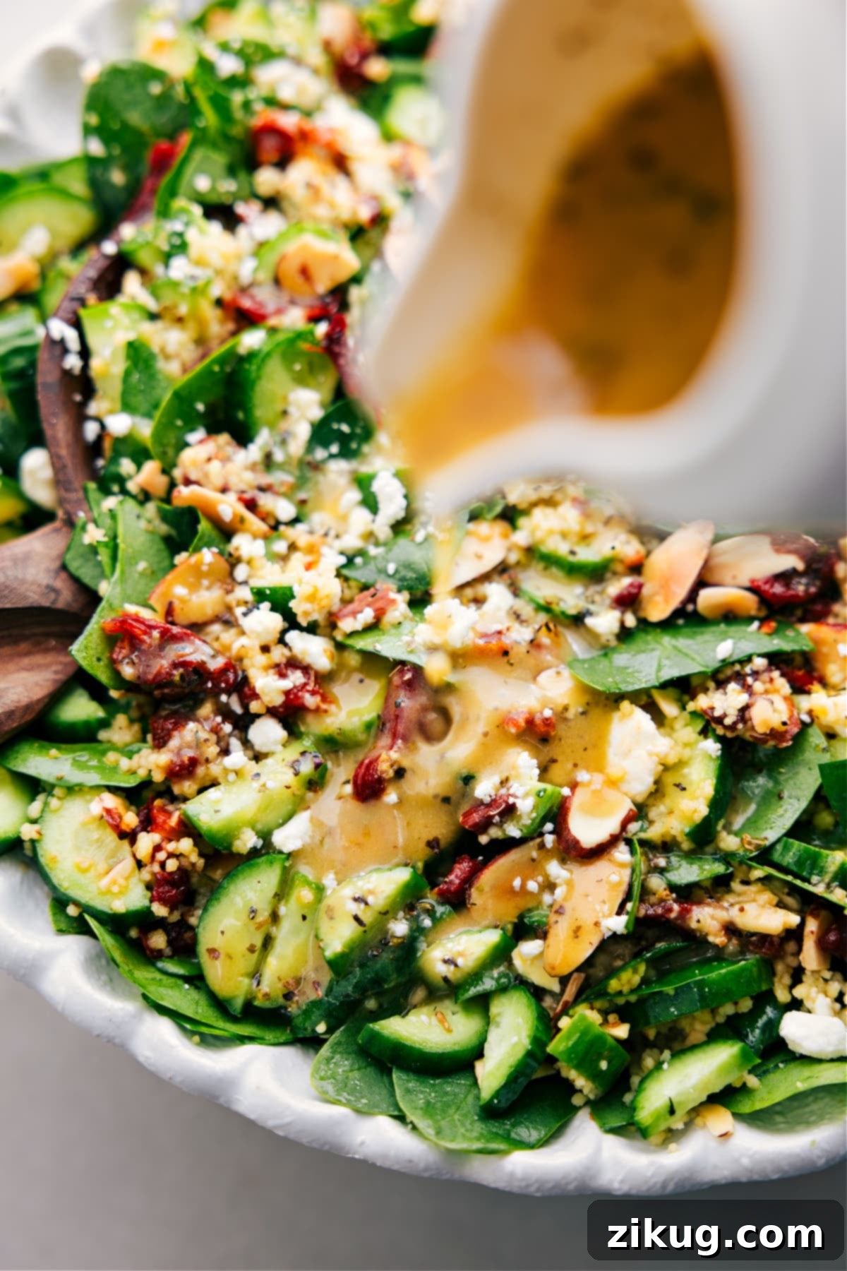 The delicious Couscous Mediterranean Salad being gently dressed with its vibrant lemon vinaigrette, ready to be tossed and served.
