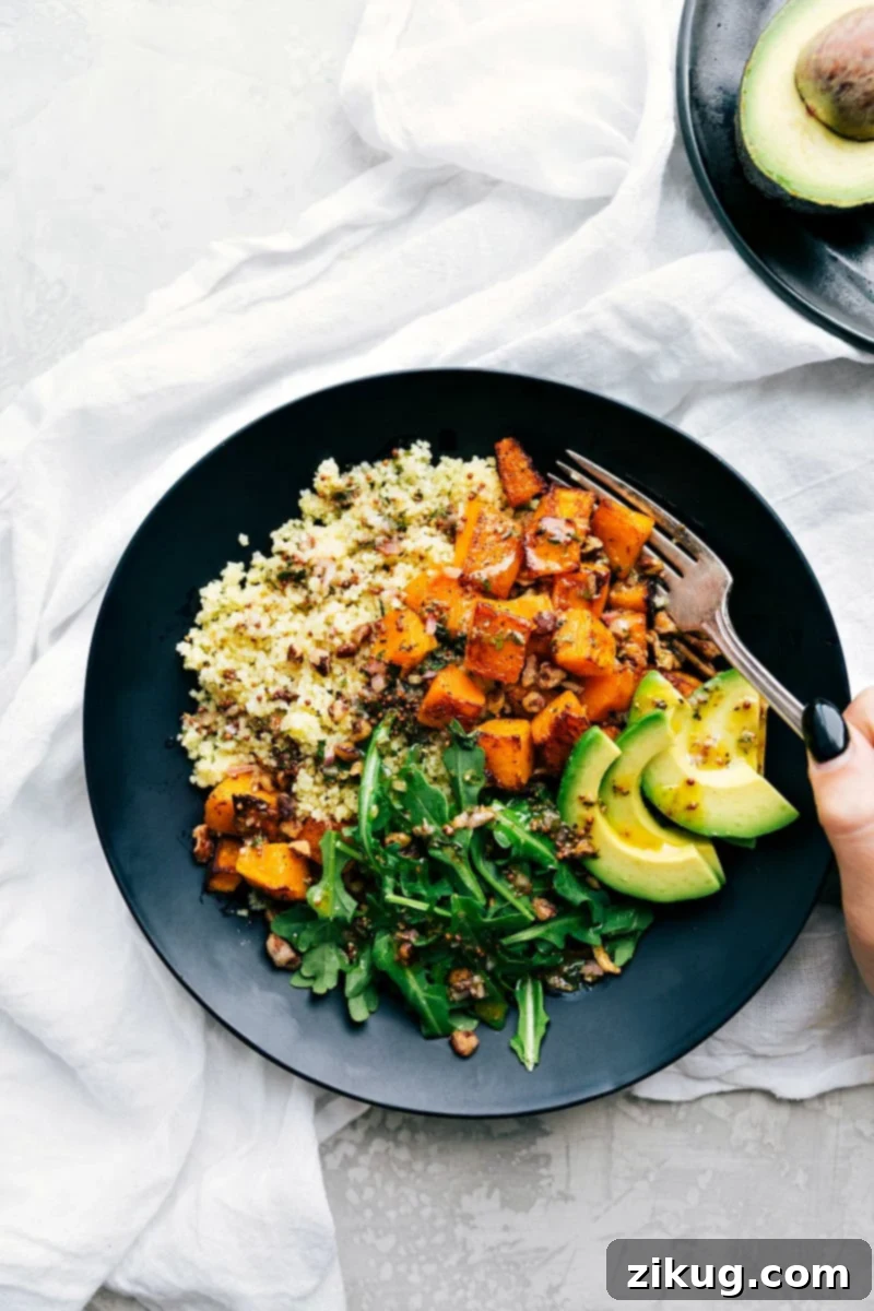 Butternut Squash Bowls: Your Perfect Healthy Fall & Winter Vegetarian Dinner A beautifully plated Butternut Squash Bowl with perfectly roasted butternut squash cubes, fluffy couscous, fresh arugula, avocado slices, and crunchy pecans, drizzled with a delicious herby dressing. This healthy, vibrant dish is perfect for autumn and winter meals.