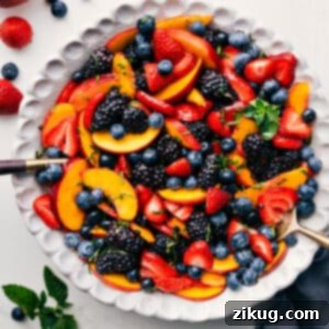 Close-up of the finished Peach Fruit Salad, glistening with dressing and vibrant colors.
