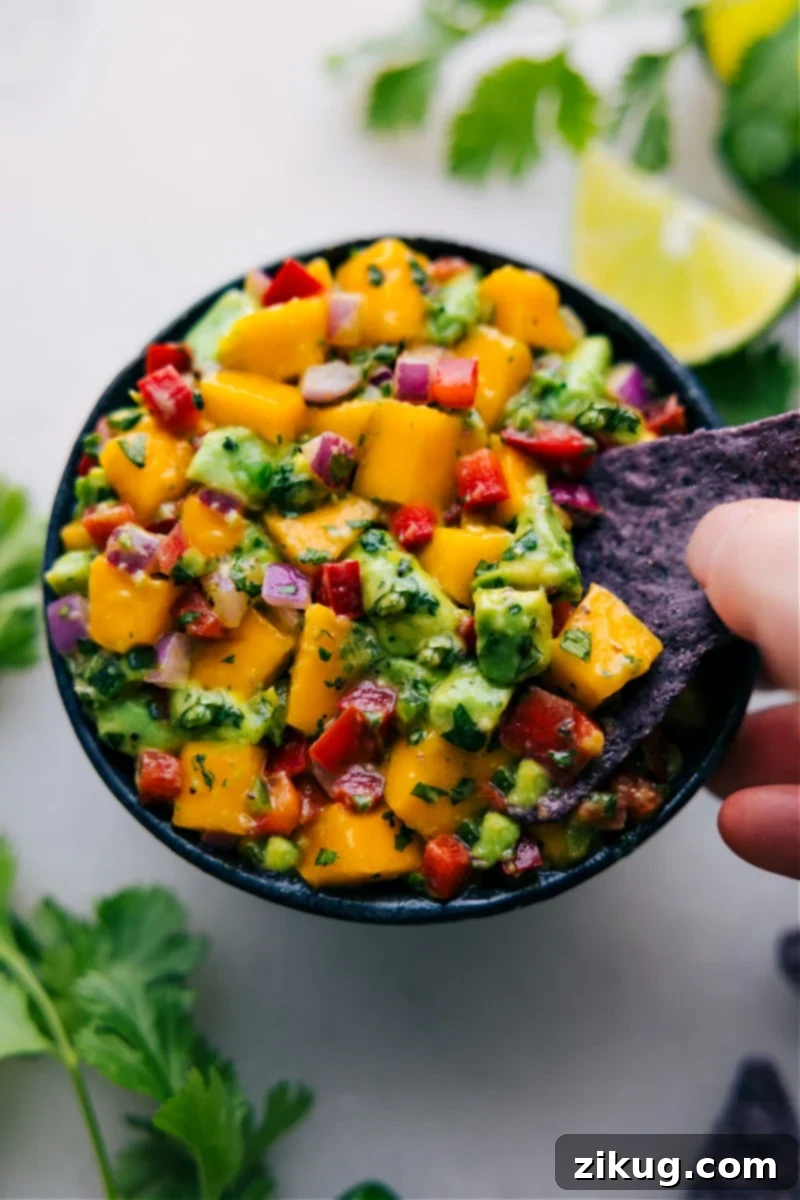 Fresh Mango Salsa 2 A vibrant bowl of fresh mango salsa, showcasing beautifully diced mangoes, red onions, bell peppers, cilantro, and creamy avocado, ready to be enjoyed.