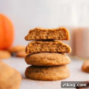 Soft & Chewy Pumpkin Snickerdoodle Cookies 3 Stack of pumpkin snickerdoodles with one cookie split open, revealing the soft, moist center.