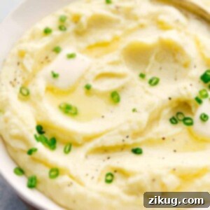 A close-up of fluffy, creamy mashed potatoes in a white bowl.