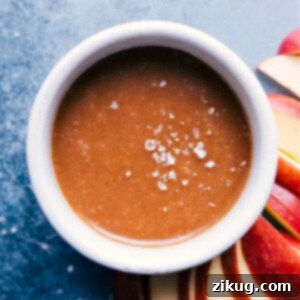 Healthy Caramel Sauce in a small white bowl with a spoon, showing its creamy texture, ready to be served.