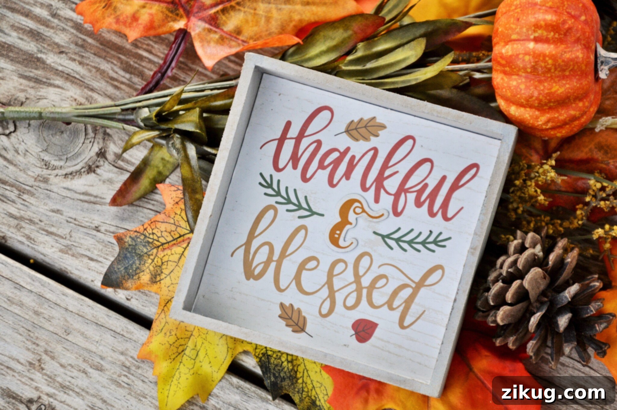 Fall foliage and a plaque that says thankful and blessed, symbolizing the gratitude and joy of Thanksgiving.