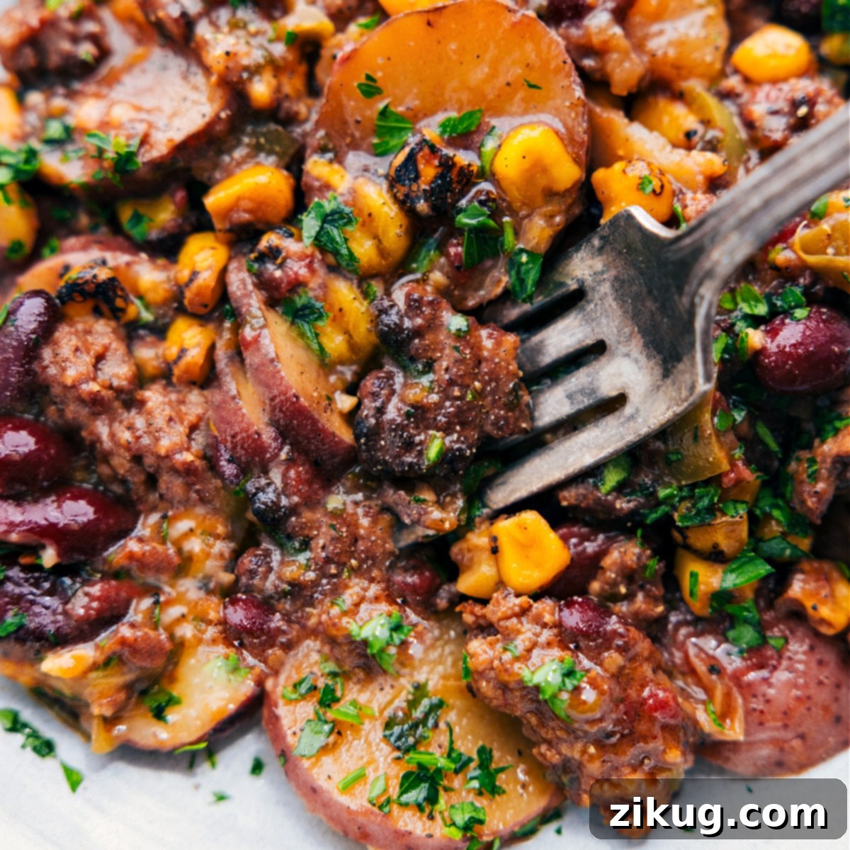 Enjoy The Best Slow Cooker Cowboy Casserole The completed dish on a plate with a big forkful.