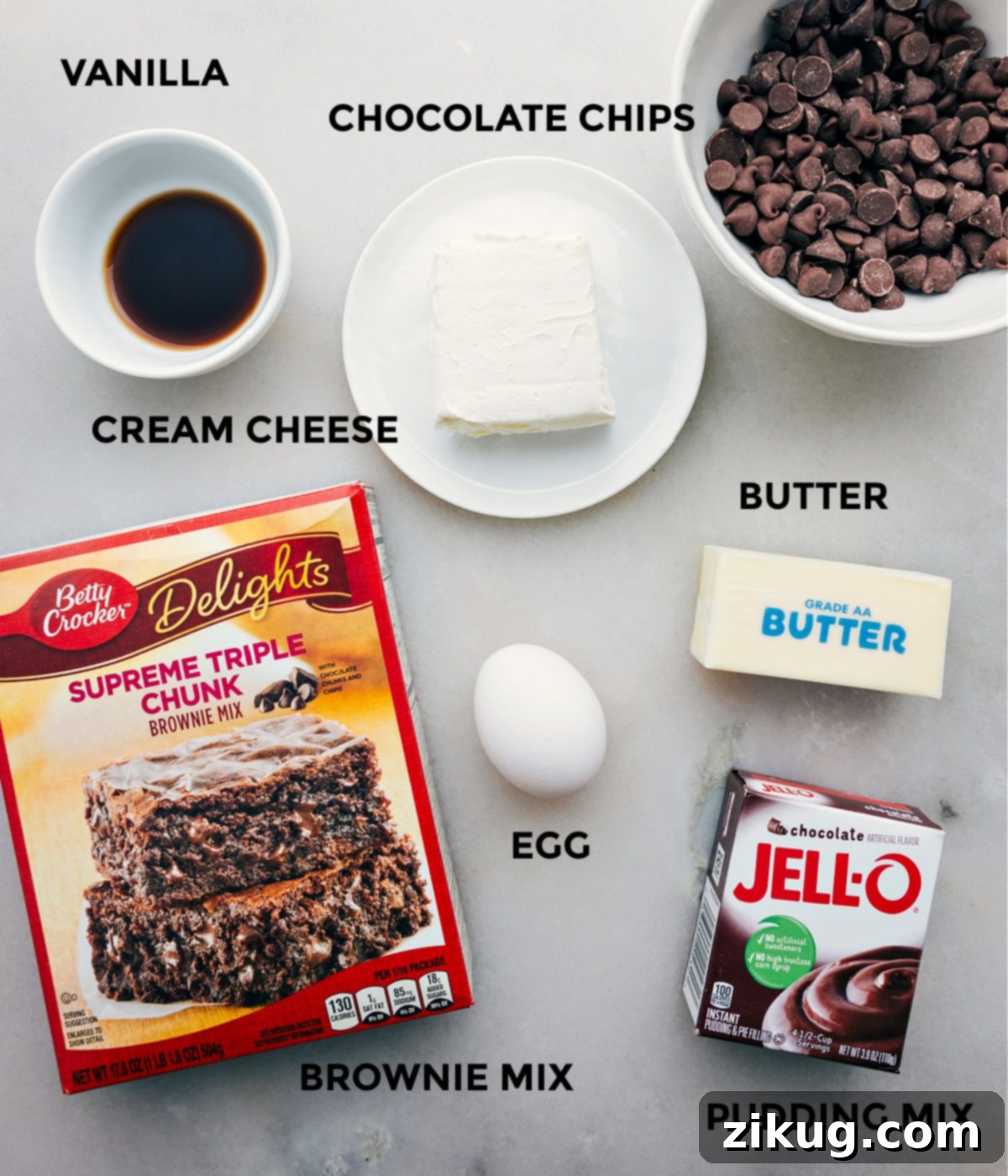Key Ingredients For Easy Brownie Cookies All essential ingredients for brownie cookies, including brownie mix, instant pudding, butter, cream cheese, egg, vanilla, and chocolate chips, neatly laid out.