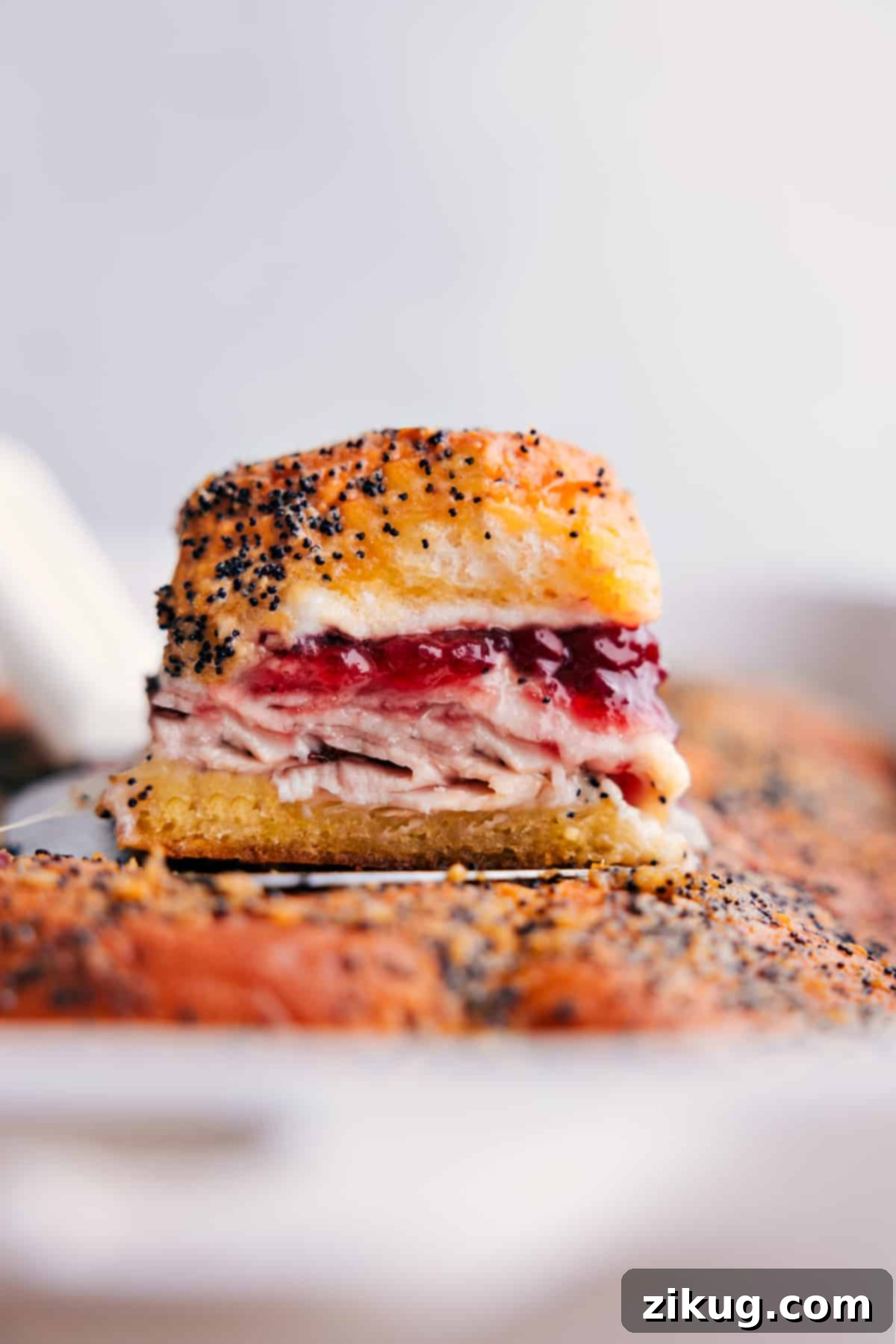Simple And Delicious Leftover Turkey Cranberry Sliders: A Crowd-Pleasing Appetizer Turkey Cranberry Sliders stacked on top of the other sliders ready to be enjoyed, showcasing the golden-brown tops and melted cheese.