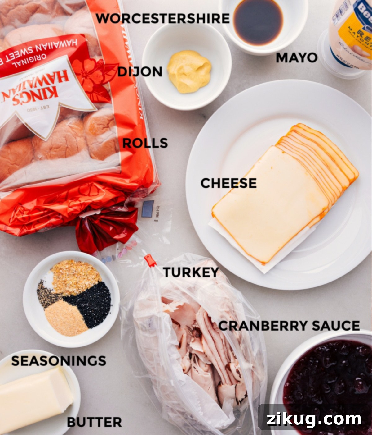 Key Ingredients for Irresistible Turkey Cranberry Sliders All the ingredients in this recipe prepped for easy assembly, including a block of Hawaiian rolls, slices of cheese, cooked turkey, cranberry sauce, mayo, and a whisked butter topping with Dijon, Worcestershire, and seasonings.