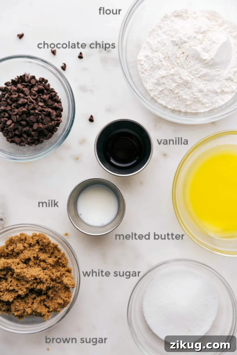 A beautifully arranged selection of ingredients for homemade edible chocolate chip cookie dough, including a bag of all-purpose flour, a stick of unsalted butter, bowls of packed brown sugar and granulated white sugar, a bottle of pure vanilla extract, a carton of whole milk, and a small dish of mini chocolate chips.