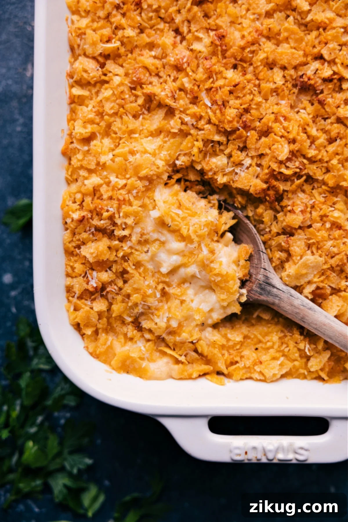 Cheesy And Delicious Funeral Potatoes: The Perfect Potluck Dish A spoonful of Funeral Potatoes scooped from the casserole dish, showcasing its cheesy texture and crispy topping.