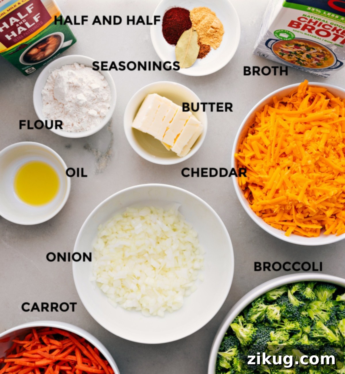 A vibrant display of fresh ingredients for Homemade Broccoli Cheddar Soup, including crisp broccoli, bright orange carrots, sharp cheddar cheese, onions, garlic, butter, flour, chicken broth, and a selection of aromatic seasonings.