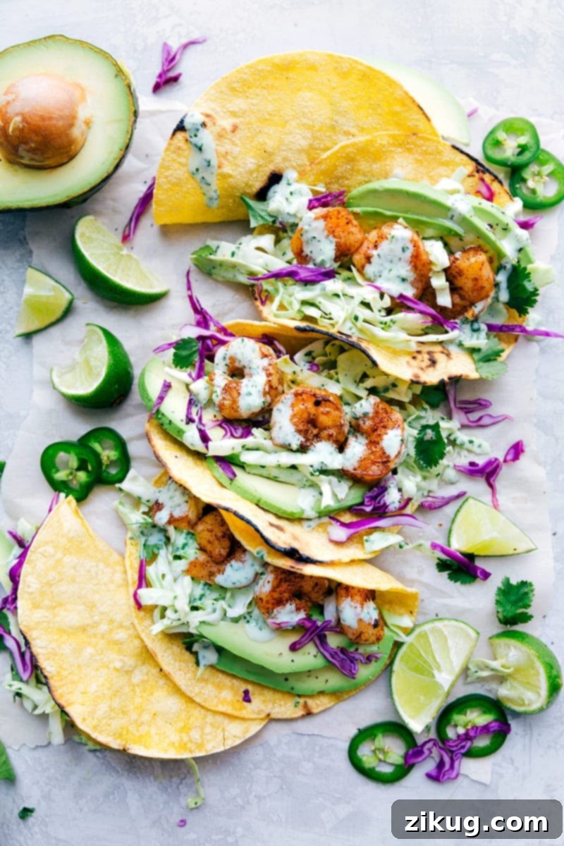 Shrimp Tacos filled with cilantro-lime slaw, avocado slices, and cotija cheese on a rustic wooden plate, ready to be enjoyed.