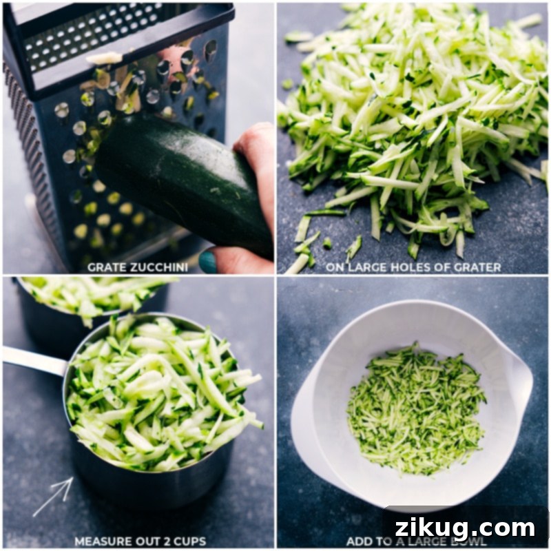 Closeup shot of grating fresh zucchini on the large holes of a box grater, showing shredded zucchini ready for the bread batter.
