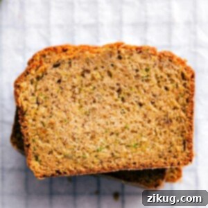 A perfectly baked slice of homemade Zucchini Bread, showcasing its moist texture and subtle green flecks.