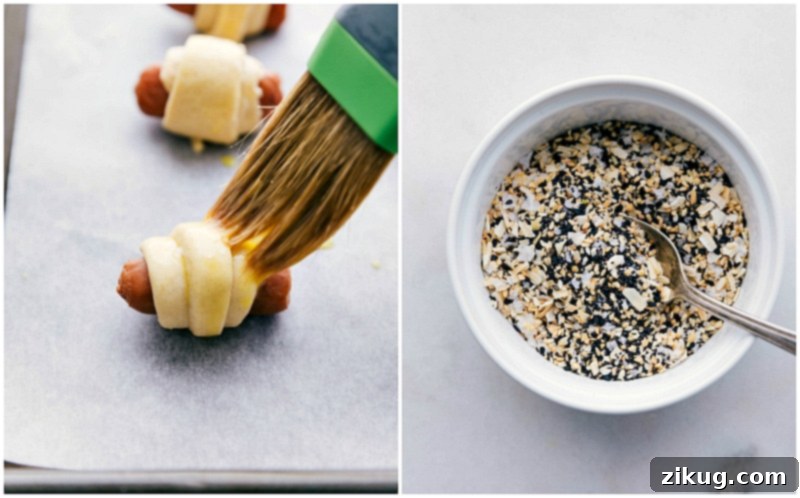 Close-up process shot showing the egg wash being brushed onto the pigs in a blanket, followed by a generous sprinkle of everything bagel seasoning.