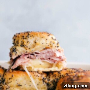 Ham and cheese sliders stacked on top of each other showing the delicious inside.