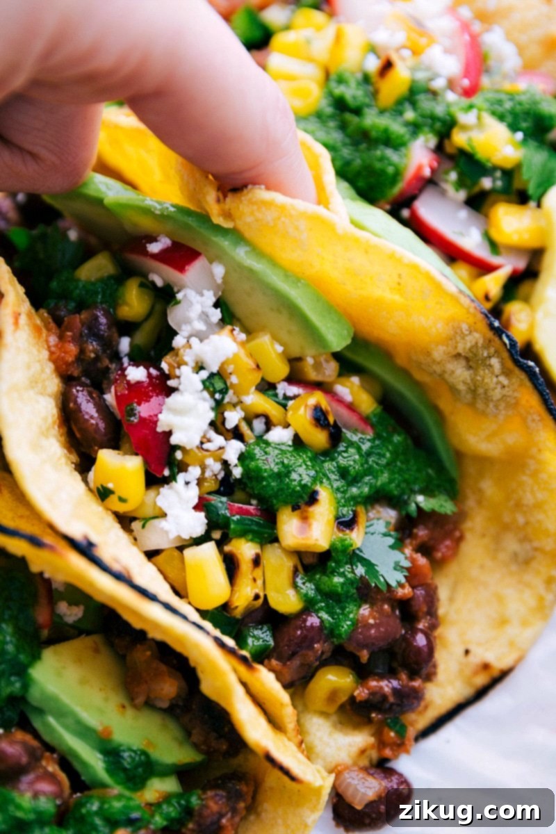 Image of a hand picking up a Healthy Black Bean Taco, ready to eat.