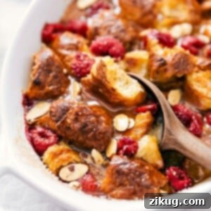 Buttery Croissant Brunch Bliss 2 Scooping golden-brown croissant bread pudding with visible chunks of bread, drizzled syrup, and fruit pieces.