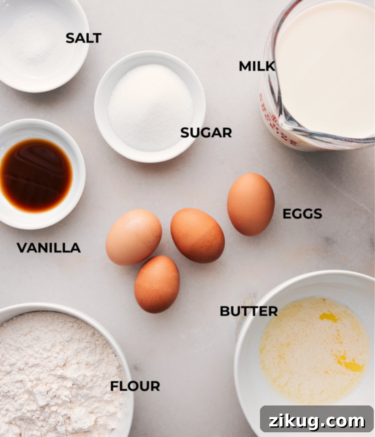 A colorful array of fresh ingredients for crepes, including milk, eggs, flour, sugar, butter, salt, and vanilla extract, beautifully arranged on a rustic wooden surface.