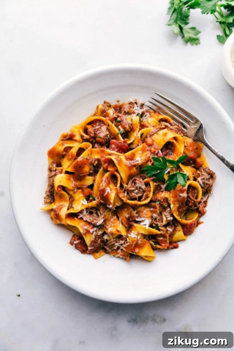 The Best Beef Ragu Recipe Homemade slow cooker beef ragu tossed with pasta and topped with freshly shredded parmesan and parsley.