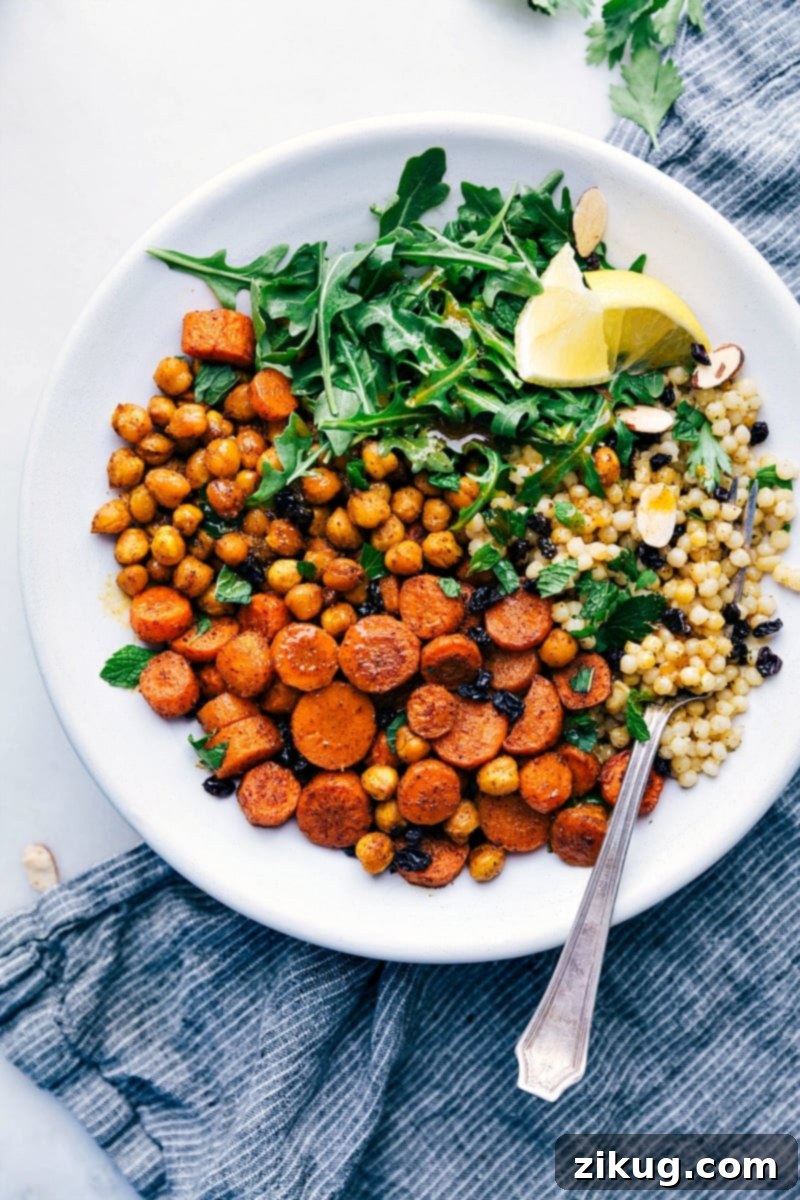 A visually stunning Moroccan Carrot Salad, showcasing roasted carrots, chickpeas, and couscous in a bowl.