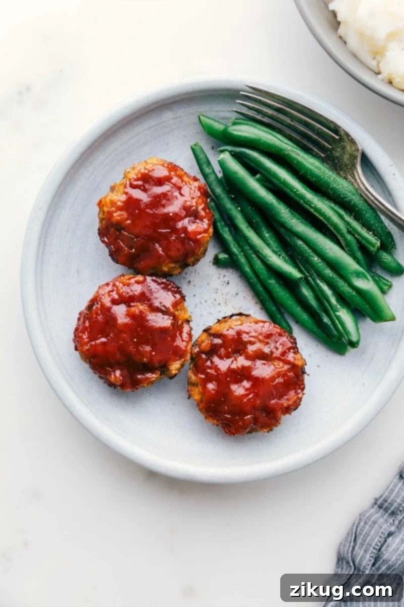 Delicious Mini Turkey Meatloaves with Green Beans Ready-to-eat mini turkey meatloaves next to vibrant green beans, showcasing a healthy and delicious meal.