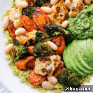 A delicious Pesto Vegetable Bowl, featuring roasted vegetables, white beans, and pesto couscous.