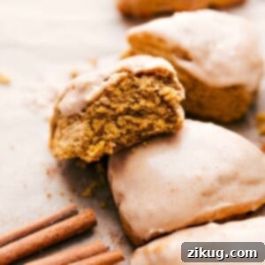 Pumpkin scones with a delectable bite missing, showcasing a perfect flaky texture.