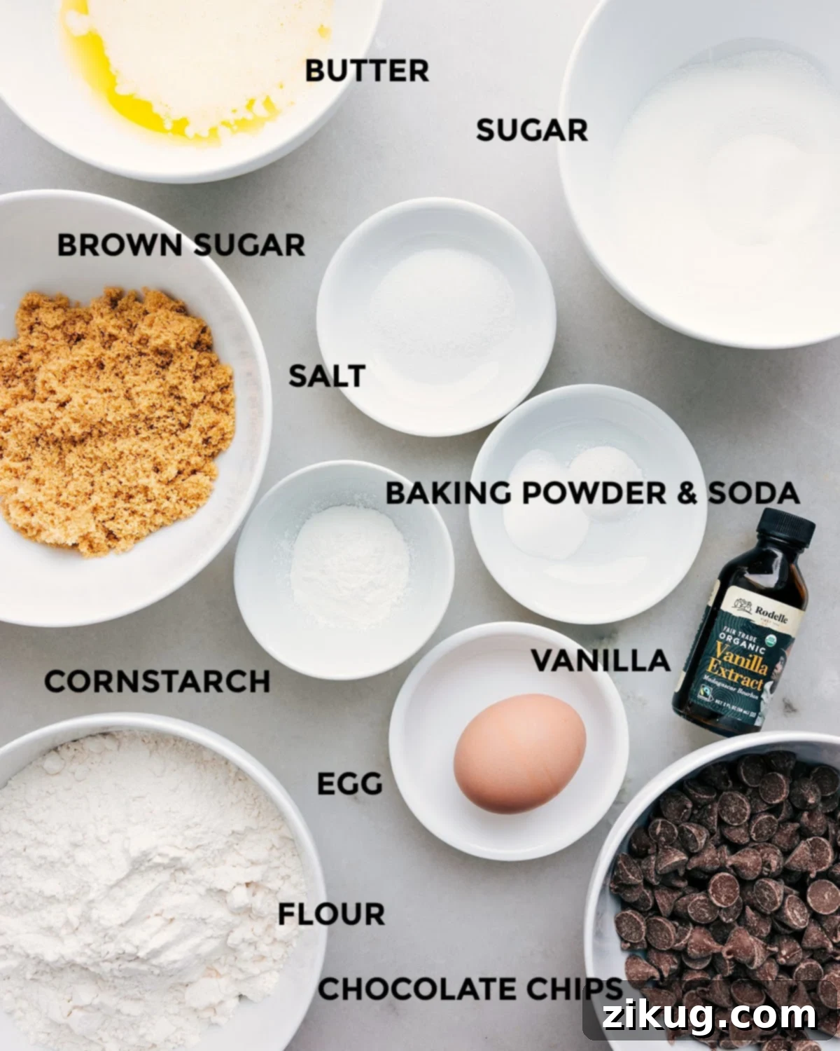 Key Ingredients for Bakery Style Chocolate Chip Cookies All the essential ingredients for bakery-style chocolate chip cookies, neatly prepped: butter, sugar, salt, baking soda, baking powder, vanilla extract, cornstarch, egg, flour, and a generous amount of chocolate chips.