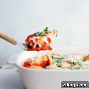 A beautifully plated serving of stuffed shells with melted cheese, rich marinara sauce, and fresh basil garnish.