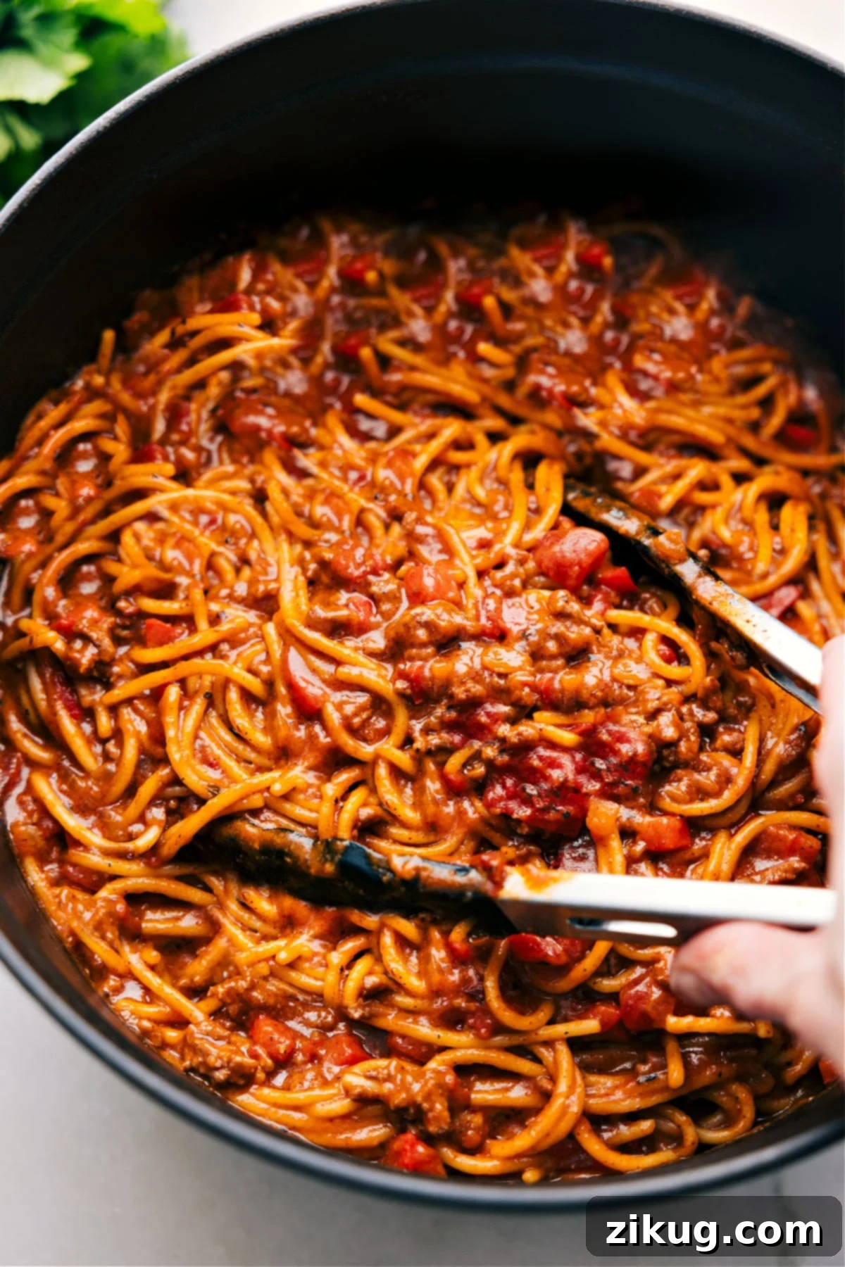 Delicious One-Pot Taco Spaghetti Recipe A large pot filled with the best One-Pot Taco Spaghetti, showcasing its rich, saucy texture and vibrant colors, with tongs poised to serve a hearty portion.