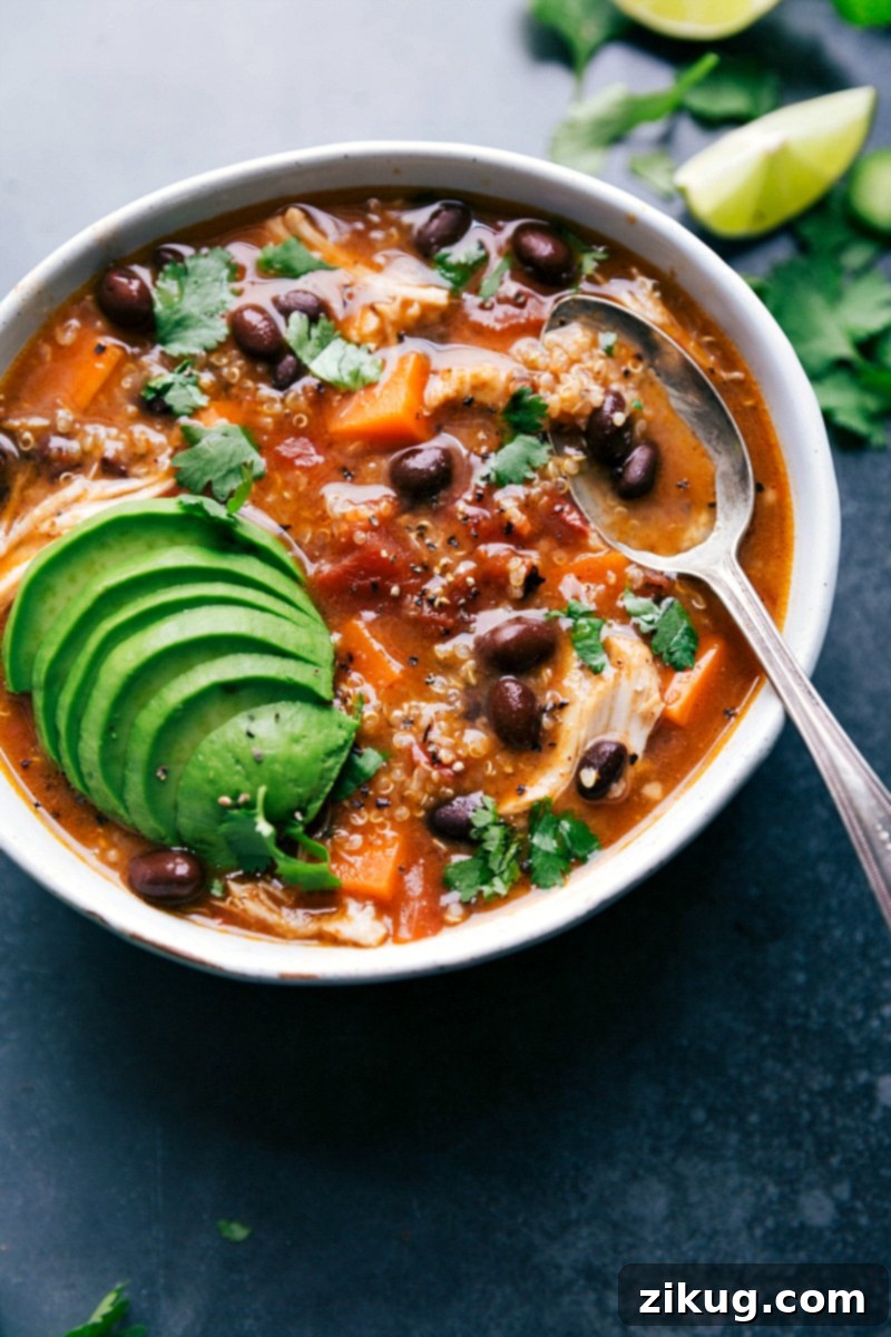 Sweet Potato Chicken Soup in a Bowl with Fresh Herbs and Avocado A beautifully presented bowl of sweet potato chicken soup, garnished generously with fresh herbs and creamy avocado slices, ready to be devoured as a delicious and wholesome meal.