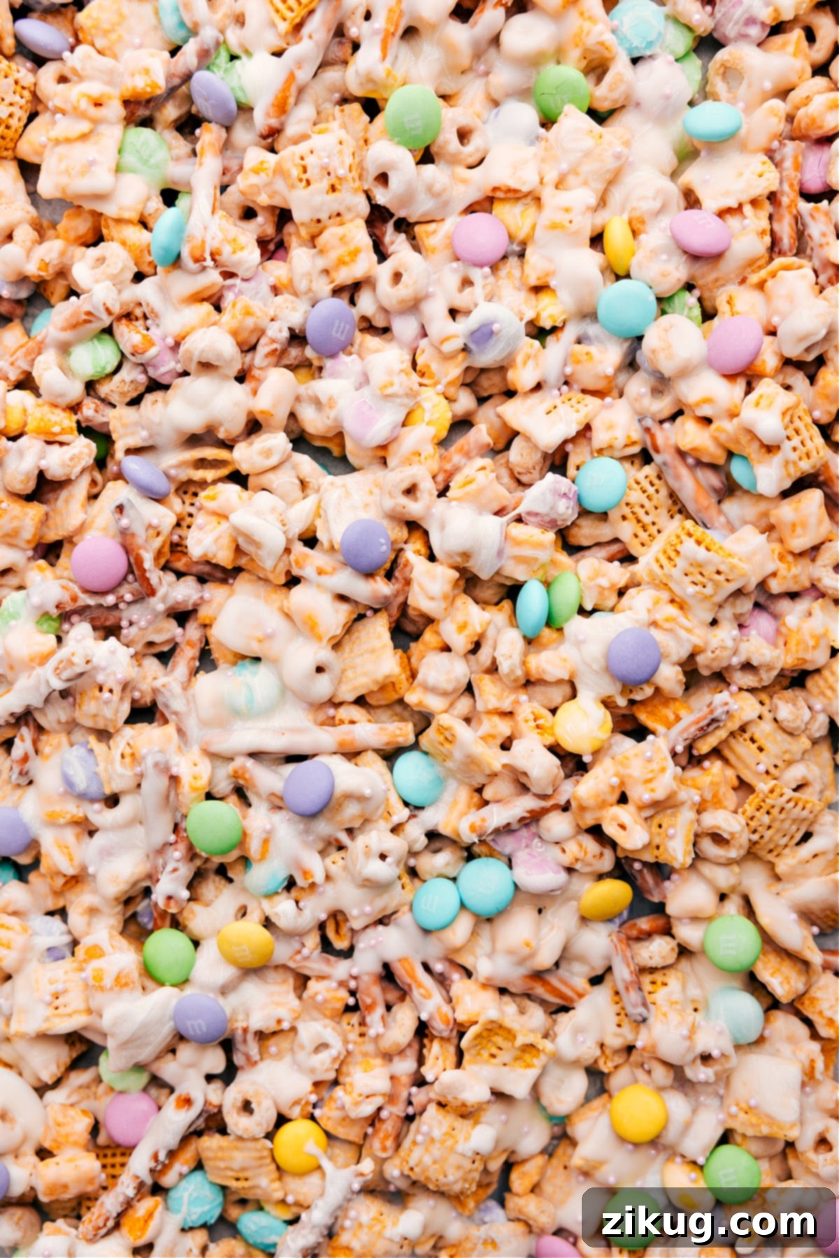 Bunny Bait recipe spread on the pan, topped with sprinkles and spring M&Ms, ready to be broken into pieces.