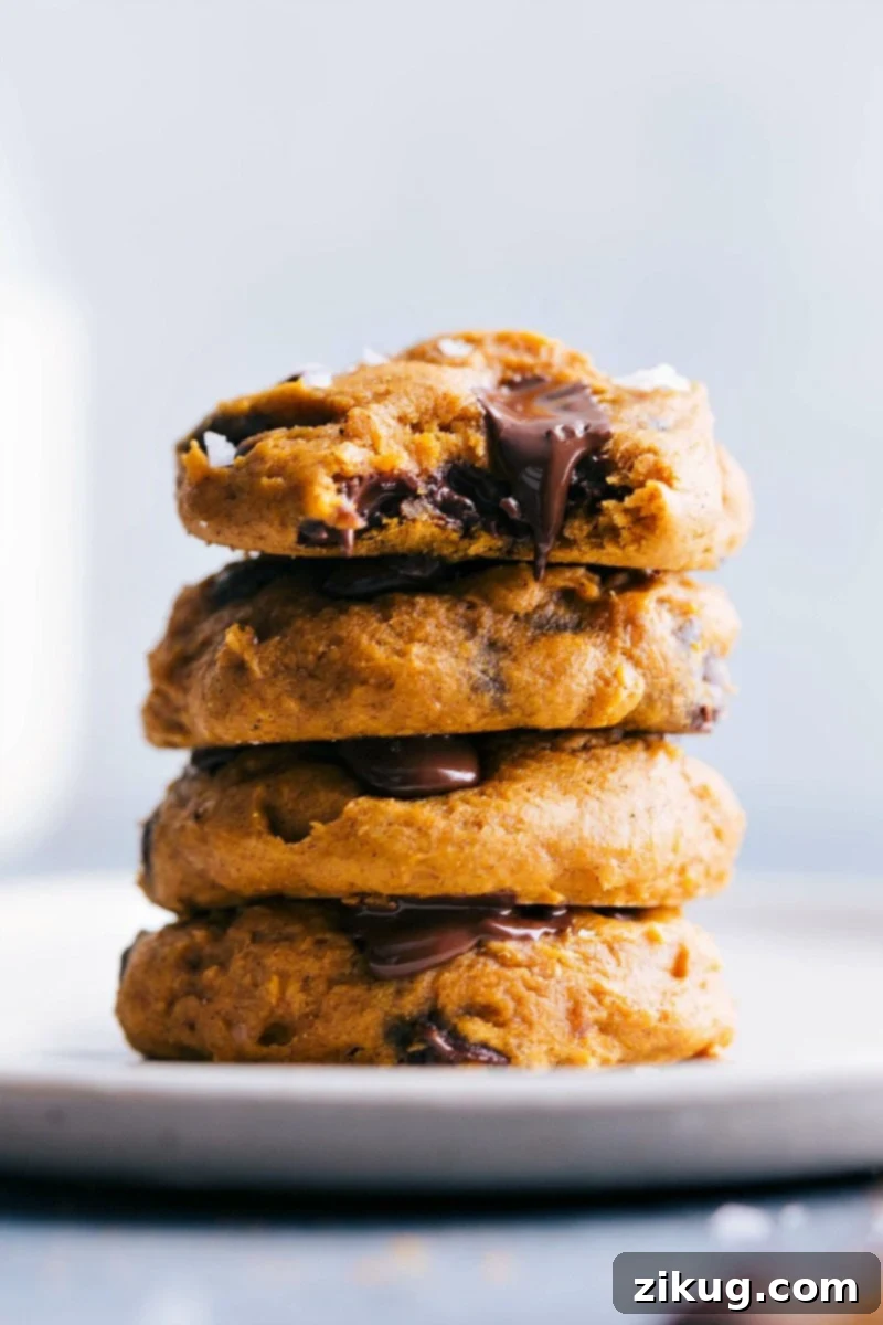 Stack of freshly baked golden-brown cake mix pumpkin cookies, ready for serving on a cooling rack.