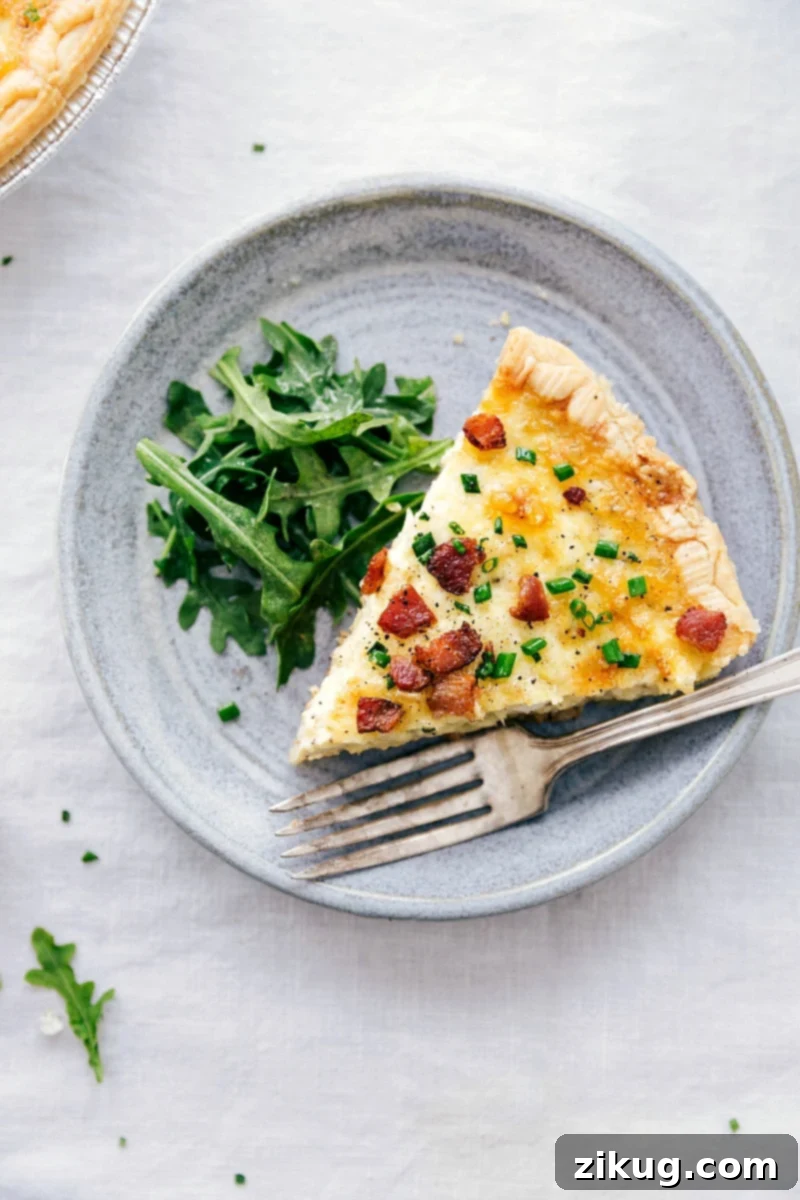 This simple Quiche Lorraine is packed with flavor! A perfect savory tart for any meal. A freshly baked, golden brown Quiche Lorraine, sliced and ready to serve, garnished with fresh chives.
