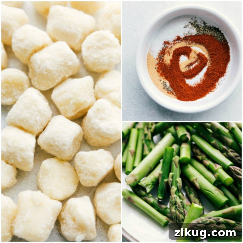 Sausage Pesto and Veggies is sure to be a hit with its vibrant colors and incredible flavors! Process shot of ingredients on a sheet pan: frozen cauliflower gnocchi, perfectly cut asparagus pieces, and a small bowl of the easy seasoning mix, all ready for roasting.