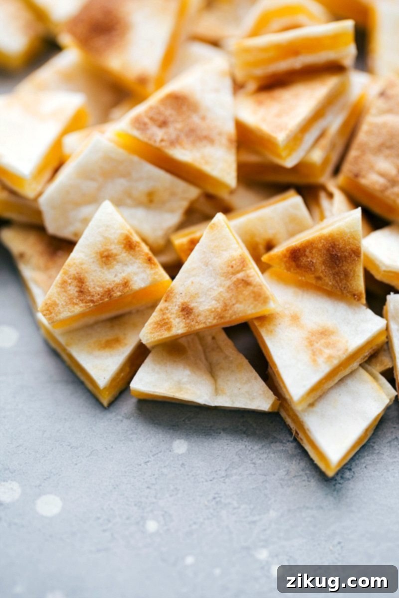 The BEST EVER Crockpot Chicken Quesadilla Soup! Dump it and forget about it and then serve with 2-ingredient quesadilla croutons! It tastes just like the Campbell's chicken quesadilla soup! recipe from chelseasmessyapron.com #chicken #soup #quesadilla #crockpot #slowcooker Image of mini cut quesadilla pieces, golden brown and cheesy, ready to be served with the chicken quesadilla soup