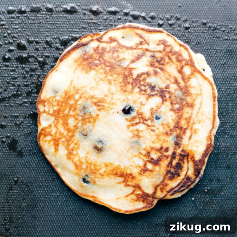 Finished breakfast on the griddle after being flipped, perfectly cooked and ready to be enjoyed.