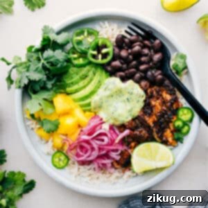 A beautifully assembled Chicken Rice Bowl with blackened chicken and avocado sauce.