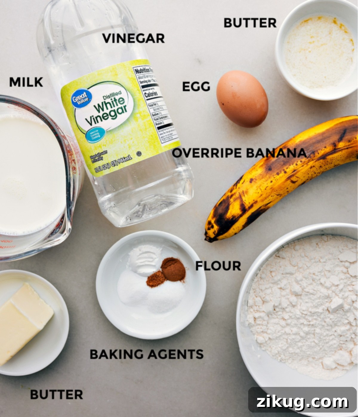 Prepped Ingredients for Homemade Banana Pancakes All the essential ingredients for making banana pancakes are neatly arranged and prepped on a counter, including ripe bananas, flour, eggs, and a bottle of syrup, ready for assembly.