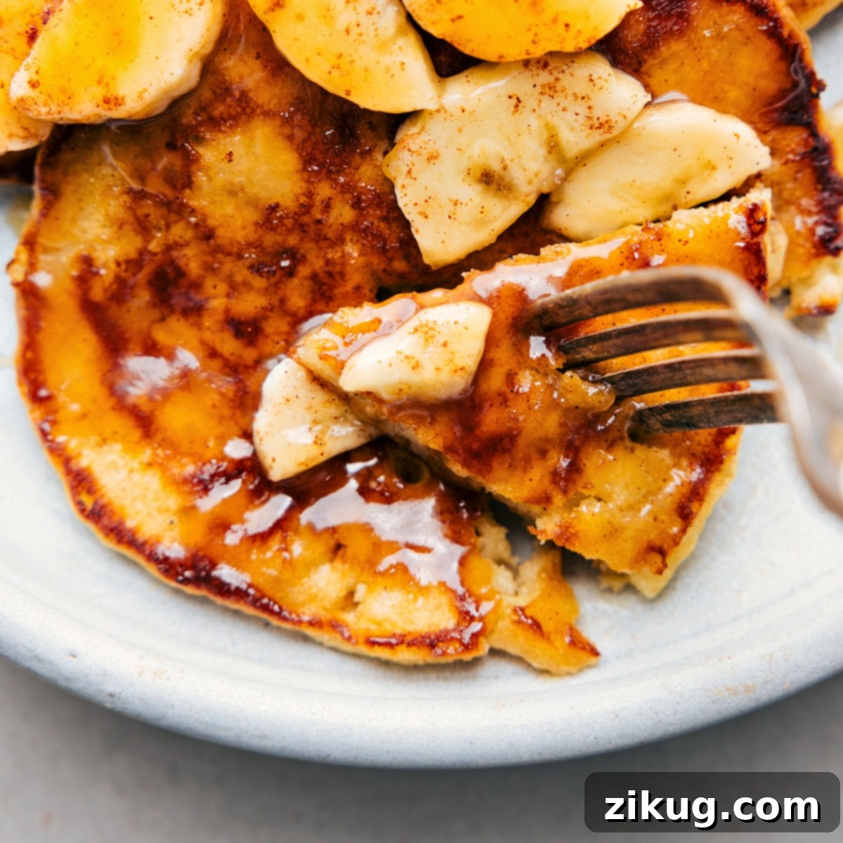 Delicious Banana Pancake with Fresh Toppings The warm breakfast revealing its fluffy interior, generously topped with fresh fruit slices and a decadent drizzle of syrup, creating an inviting and delicious start to the day.