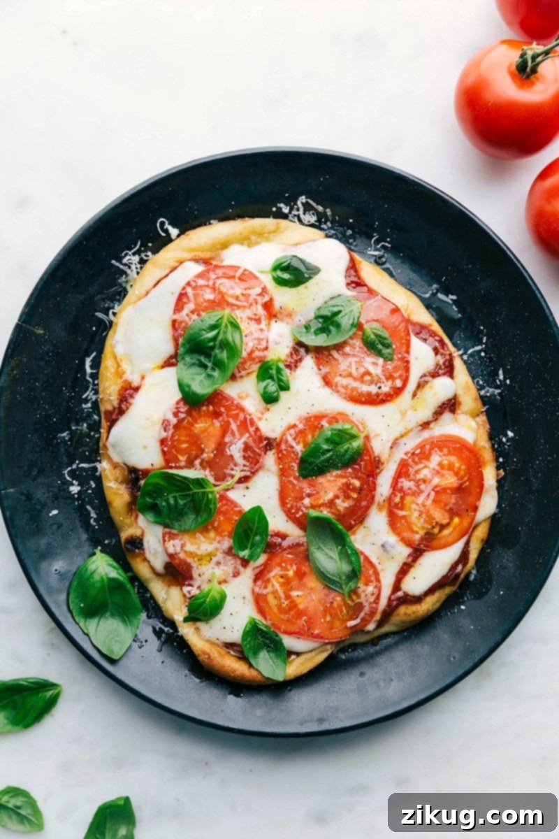Delicious Baked Naan Pizza Topped with Fresh Basil, Melted Cheese, and Vibrant Toppings on a Plate A delicious baked naan pizza on a plate, topped with fresh basil leaves, melted cheese, and vibrant toppings.