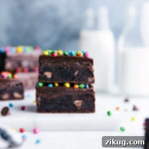 A freshly baked cosmic brownie with rich chocolate frosting and colorful rainbow sprinkles.