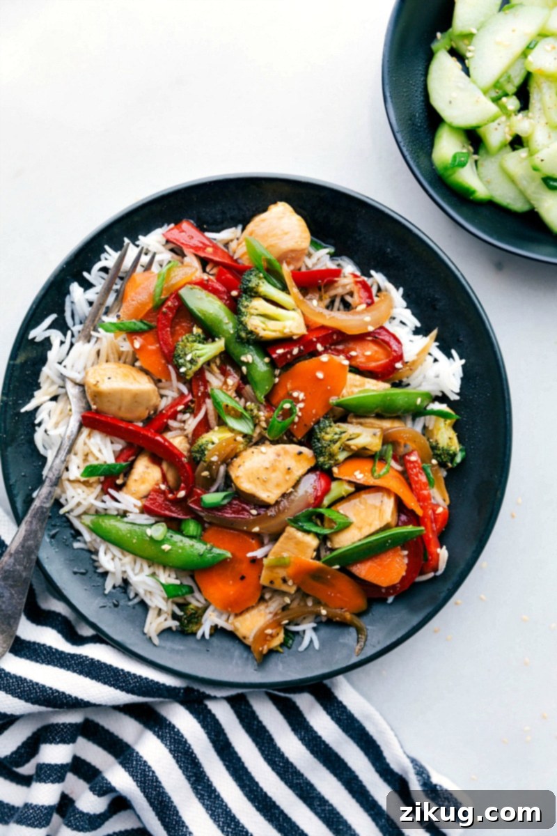 Stir Fry Delight - Chicken Over Rice, Ready for Enjoyment Flavor-packed stir fry chicken served in a bowl over a bed of rice, ready to be enjoyed.