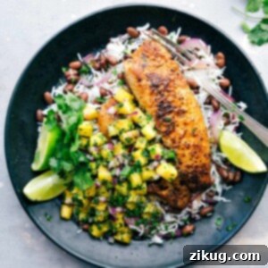 Cajun Blackened Tilapia 4 A plate featuring blackened tilapia served with pineapple salsa, rice, and black beans, presenting a flavor-packed and delicious meal.