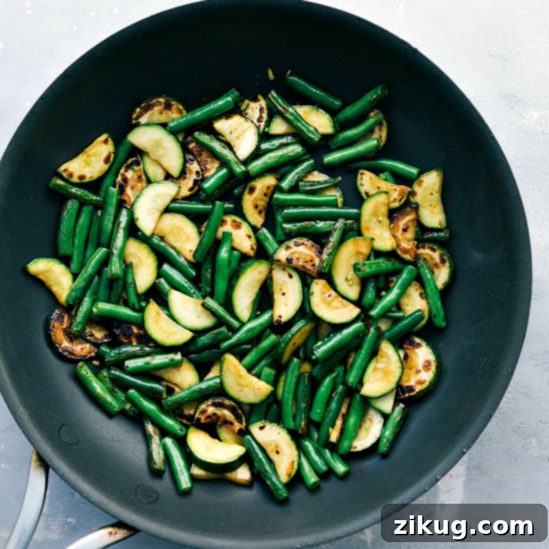 Cooking Mastery: Perfectly Prepared Zucchini and Green Beans in a Saucepan Perfectly cooked zucchini and green beans simmering in a saucepan, tender, vibrant, and infused with flavor.