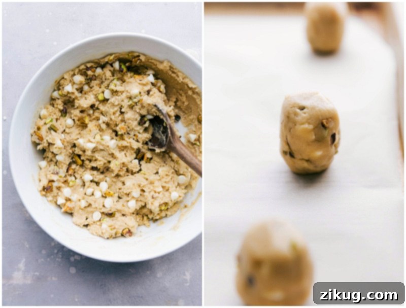 Cookie Dough Rolled into Balls for Baking The perfectly prepared cookie dough, rolled into evenly-sized, tall cylindrical balls, neatly arranged on a baking sheet. Each ball is ready to be placed in the oven, promising delicious, chewy pistachio cookies.