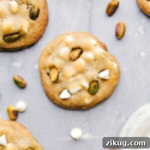 A batch of freshly baked pistachio cookies, baked to a golden-brown perfection, filled with flavor, white chocolate chips, and pistachio bits, ready to be savored.